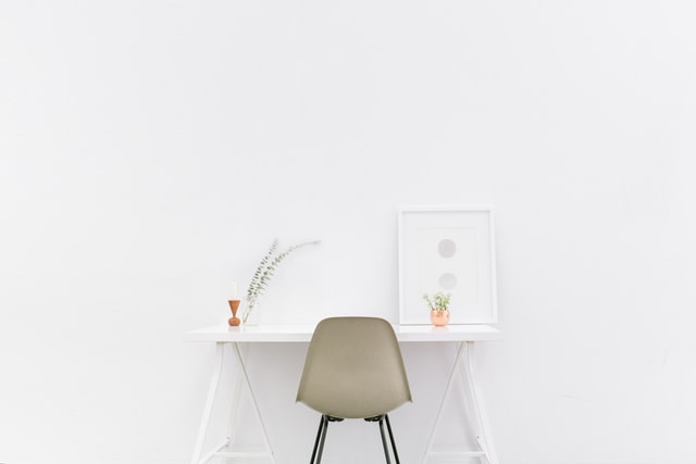 a chair white chair at a white desk on a white wall